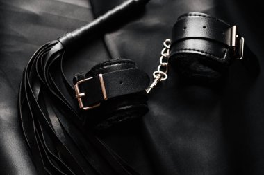 Egemenlik ve boyun eğme için BDSM seks oyuncakları. Deri kamçı ve kelepçe.