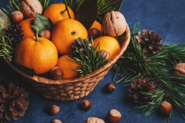 Çam kozalaklarıyla süslenmiş mandalina, ceviz ve fındık