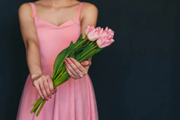 Chica en un vestido rosa sosteniendo un ramo de tulipanes — Foto de Stock