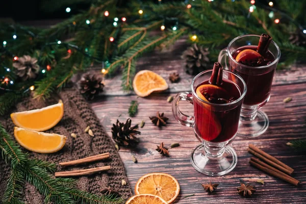 Két pohár forralt bor, fűszerek és narancs szelet, egy fából készült asztal. Forró alkoholos ital — Stock Fotó