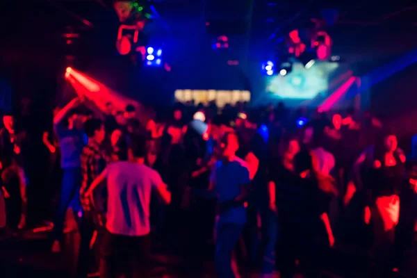 Sagome sfocate di persone che ballano in un nightclub — Foto Stock