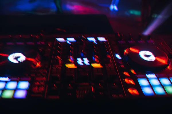 DJ mixér v nočním klubu s pozadím zářících světel z tlačítek — Stock fotografie