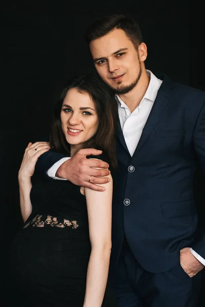 Feliz joven elegante pareja de moda sonriendo. Hombre y mujer embarazada —  Fotos de Stock