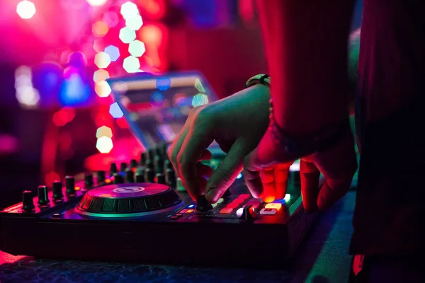 Mãos DJ tocando e misturando música no controlador de música em uma festa — Fotografia de Stock