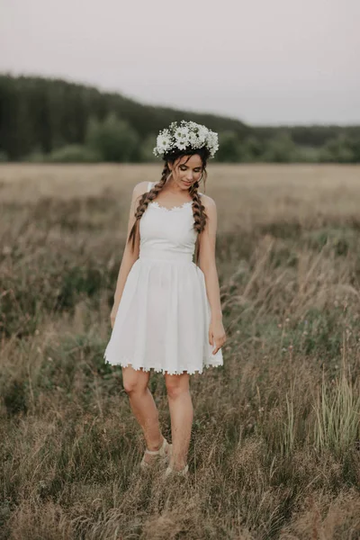 Lány zsinórra és a virág koszorút fehér boho ruha nyáron a szabadban — Stock Fotó