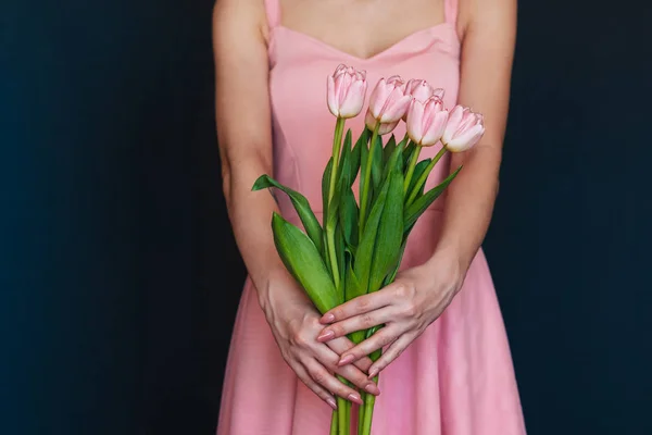 Ramo de tulipanes rosados en las manos de una niña — Foto de Stock