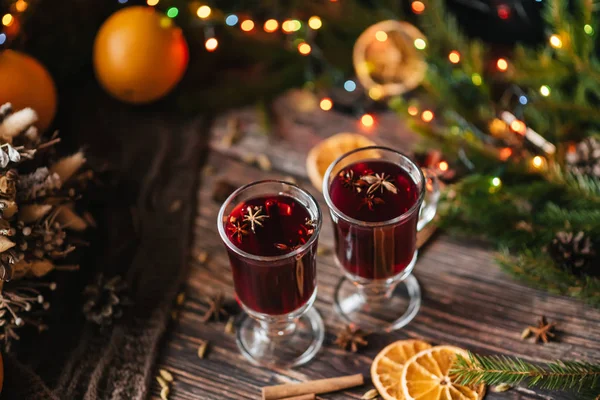 İki bardak portakal, tarçın, kakule ile ahşap bir masa üzerinde mulled şarap ile Anason yıldız. Geleneksel kış sıcak alkollü içecek — Stok fotoğraf