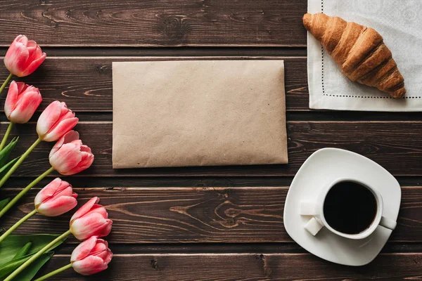 Strauß rosa Tulpen mit einer Tasse Kaffee und einem Croissant — Stockfoto