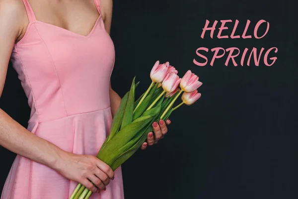 Ramo de tulipanes rosados en las manos de una niña. Tarjeta de felicitación con texto Hello Spring — Foto de Stock