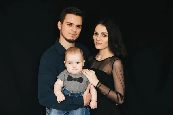 I giovani genitori caucasici stanno tenendo in braccio un bambino. Felice mamma, papà e figlio — Foto Stock