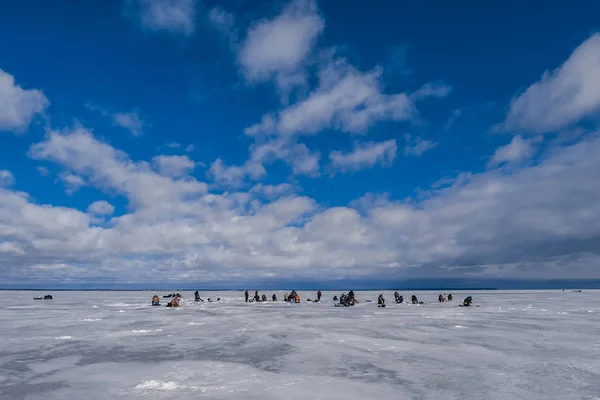 Fishermen catch fish in winter on the ice on a day — Stock Photo, Image