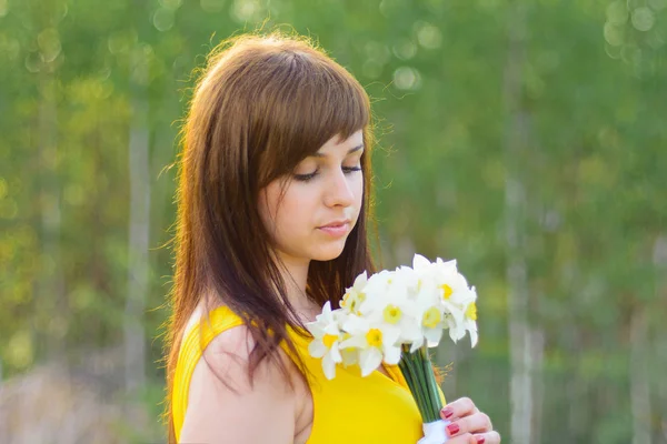 Ritratto di una giovane ragazza con un mazzo di narcisi primavera — Foto Stock