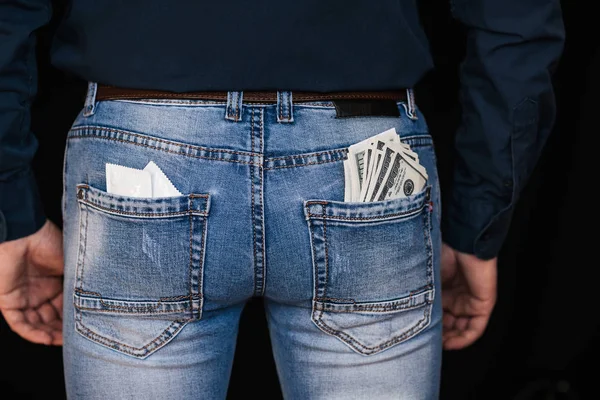 Kondomer och sedlar pengar i bakfickor Mäns jeans — Stockfoto