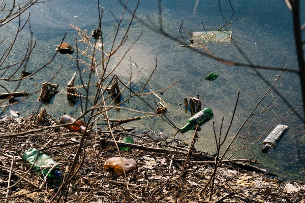 VICHUGA, RUSIA - 21 DE ABRIL DE 2019: Botellas de plástico y vidrio en la orilla del río —  Fotos de Stock