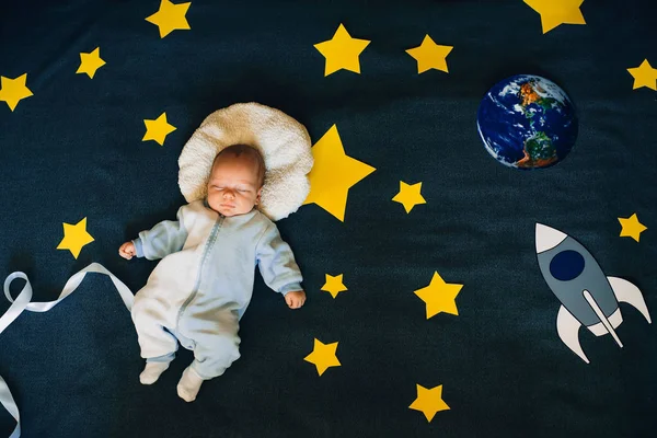 Bébé garçon dort sur le fond du ciel étoilé avec une fusée et la planète — Photo