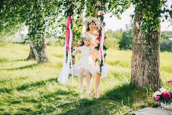 Szczęśliwa matka i córka wahadłowy na słoneczne lato huśtawki — Zdjęcie stockowe