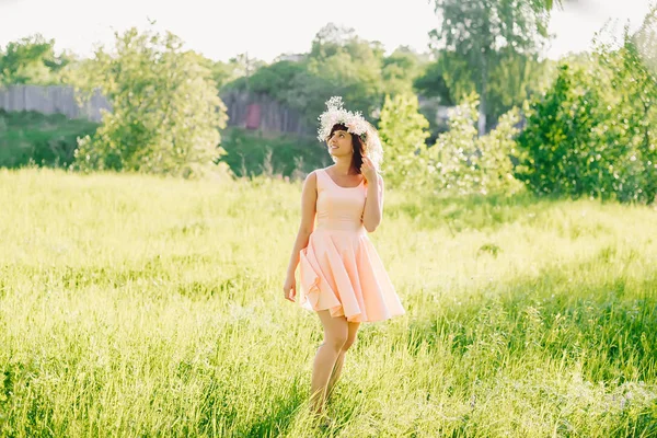 Beyaz görünüm üzerinde bir çayır başında bir çelenk ile elbiseli güzel kız — Stok fotoğraf