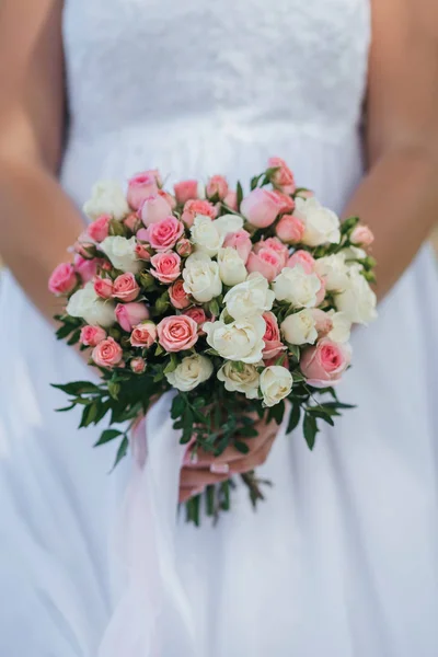 Bouquet de mariage avec des roses roses et blanches dans les mains de la mariée — Photo