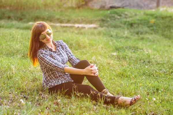 Молодая девушка отдыхает на поле на закате летом — стоковое фото