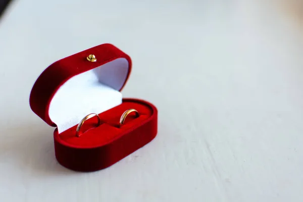 Par de anillos de boda de oro se encuentran en una caja roja — Foto de Stock