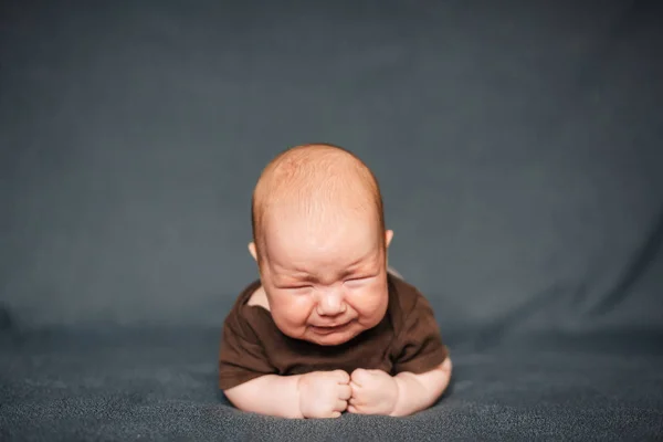 生まれたばかりの赤ちゃん男の子が泣いています。白人の子供が横になっています。 — ストック写真