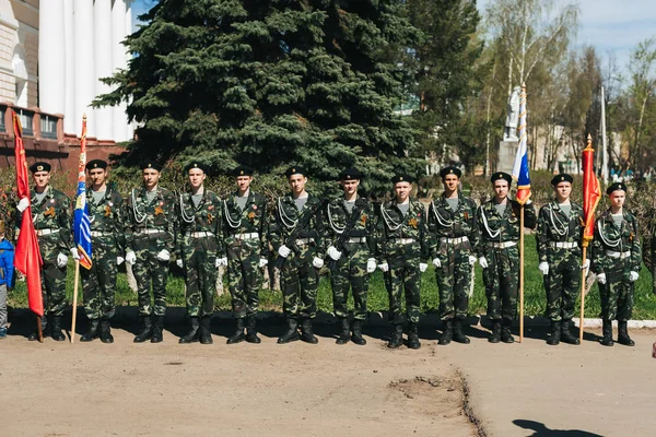 VICHUGA, RÚSSIA - 9 de maio de 2018: Jovens de uniforme militar com fitas de São Jorge e bandeiras no desfile em honra da vitória na Segunda Guerra Mundial — Fotografia de Stock