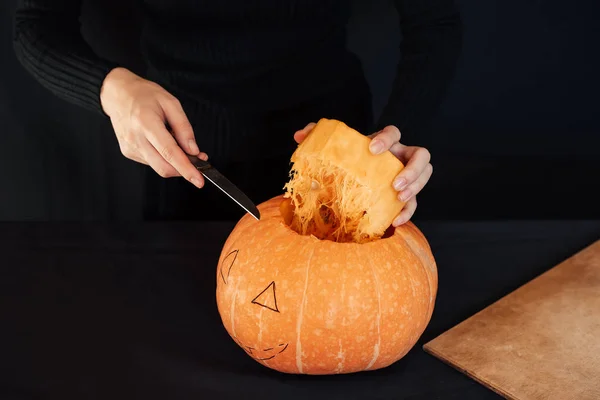 Halloween. Dziewczyna ręce z nożem cięcia pomarańczowy dyni do produkcji Jack latarnia — Zdjęcie stockowe