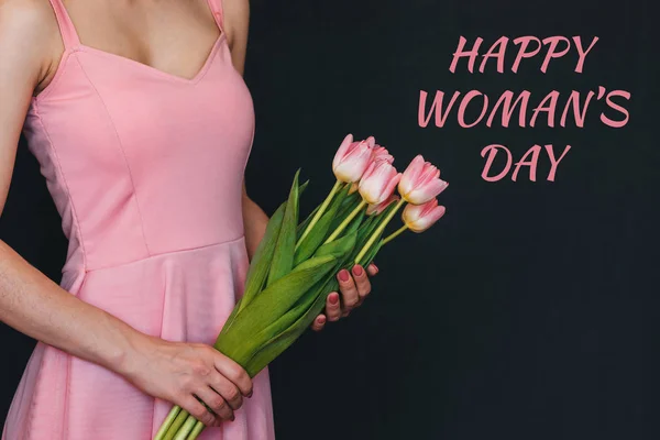 Bouquet of flowers of pink tulips in the hands of a girl. Greeting card with text Happy Women's Day — Stock Photo, Image