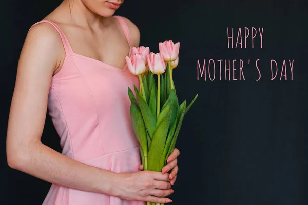 Bouquet of flowers of pink tulips in the hands of a girl. Greeting card with text Happy Mother's Day — Stock Photo, Image