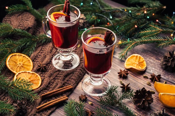 Χριστουγεννιάτικο ζεστό κρασί με πορτοκάλι, μπαχαρικά σε ένα ξύλινο τραπέζι — Φωτογραφία Αρχείου