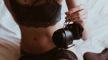 yatak odasında yatakta iç çamaşırı genç bir kızın elinde Bdsm seks seksi rol oynama ve teslim için deri kelepçe.