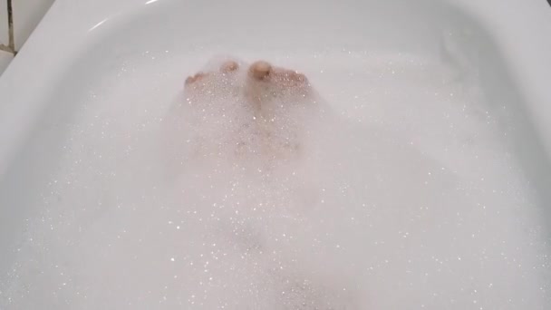 Bella ragazza bruna accarezza sessualmente la gamba e canta in bagno con schiuma — Video Stock