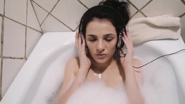 美丽的女人在耳机在洗澡唱歌 — 图库视频影像
