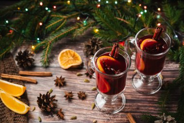Noel mulled şarap ile portakal, ahşap bir masaya baharat