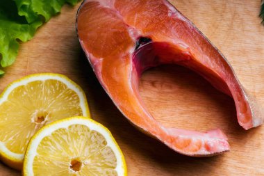 limon dilimleri ile kesme tahtası üzerinde taze somon