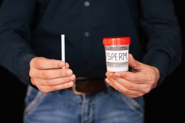 Erkek bir içicinin elinde bir kutu sperm ve bir sigara.