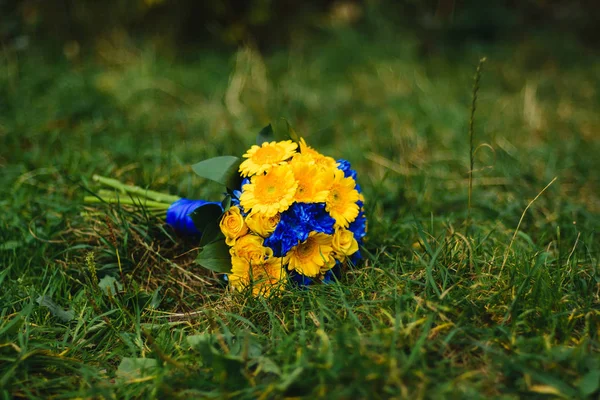 Ramo de flores de boda se encuentra en la hierba — Foto de Stock