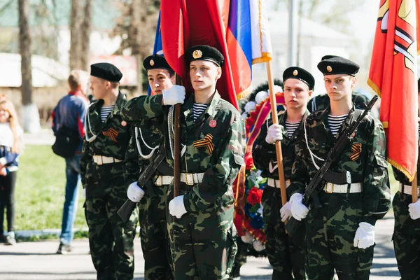 VICHUGA, RUSSIE - 9 MAI 2018 : De jeunes hommes en uniforme au défilé de la victoire de la Seconde Guerre mondiale avec drapeaux — Photo