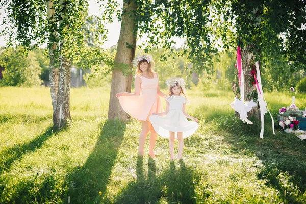 Mamá y su hija posando en el parque en un verano soleado — Foto de Stock