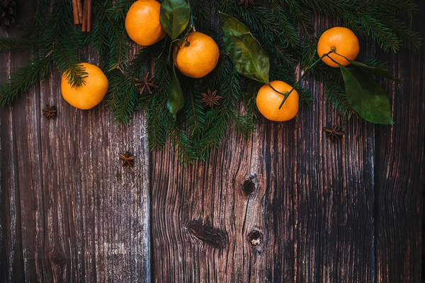 みかん、モミの枝、シナモン、スターアニスをクリスマスの背景。お祭り冬の装飾的なフレーム — ストック写真