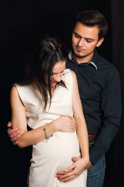 快乐的怀孕女孩和男人抱着肚子。年轻家庭的概念 — 图库照片