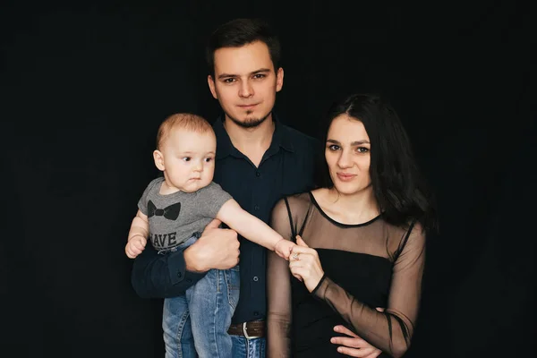 I giovani genitori caucasici stanno tenendo in braccio un bambino. Felice mamma, papà e figlio — Foto Stock