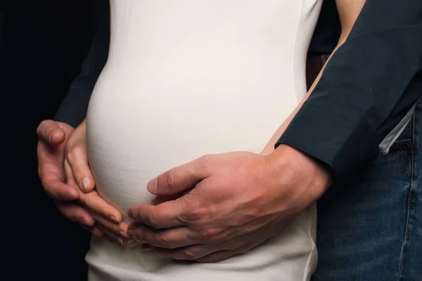Mains gars sur le ventre d'une fille enceinte — Photo
