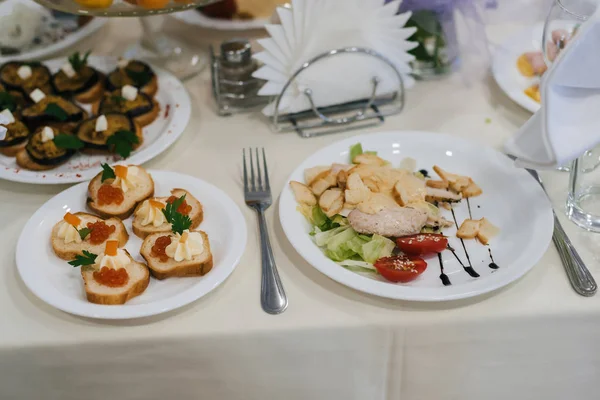 Салат Цезарь и другие разнообразные закуски на праздничном столе — стоковое фото