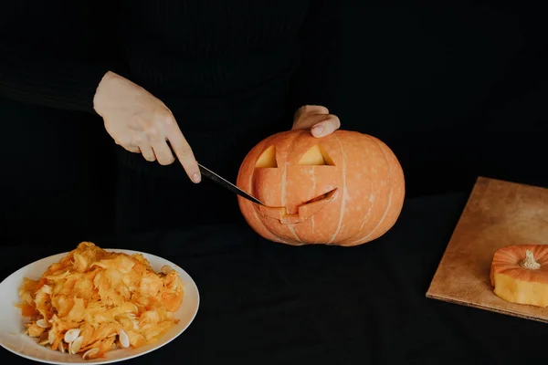 Halloween. Mädchenhände mit einem Messer schneiden Orangenkürbis für Jack 's Laterne — Stockfoto