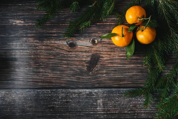 木製のテーブルの上にモミの枝とみかんを持つクリスマスの背景 — ストック写真