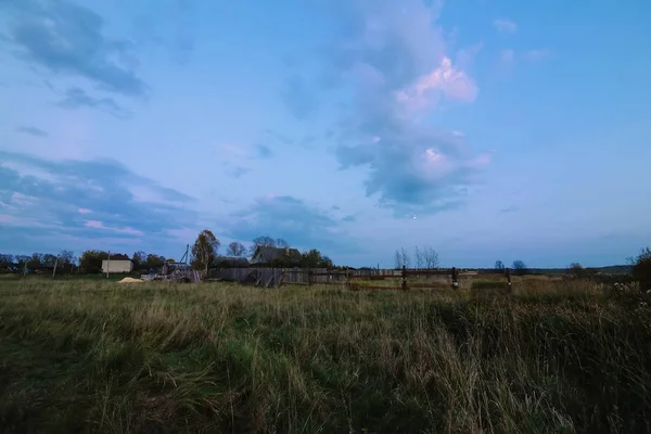 rural landscape with a house in the village in the evening at dusk in autumn