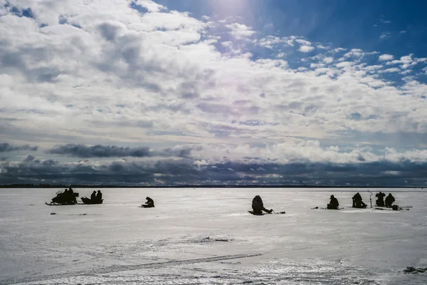Siluetas de pescadores pescando y moto de nieve en invierno en el hielo — Foto de Stock