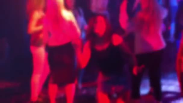Verschwommene Silhouetten einer Menge tanzender Menschen auf der Tanzfläche in einem Nachtclub — Stockvideo