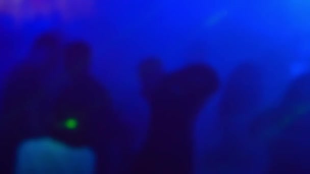 Silhouette sfocate di un gruppo di persone che ballano sulla pista da ballo in un nightclub — Video Stock